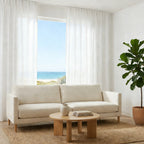 Bright minimalist lounge featuring floor to ceiling White Sarah Semi Sheer Curtains next to a fiddle leaf fig
