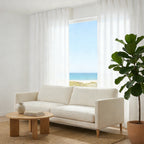 Coastal living room with breezy White Sarah Semi Sheer Curtains revealing a beautiful ocean view