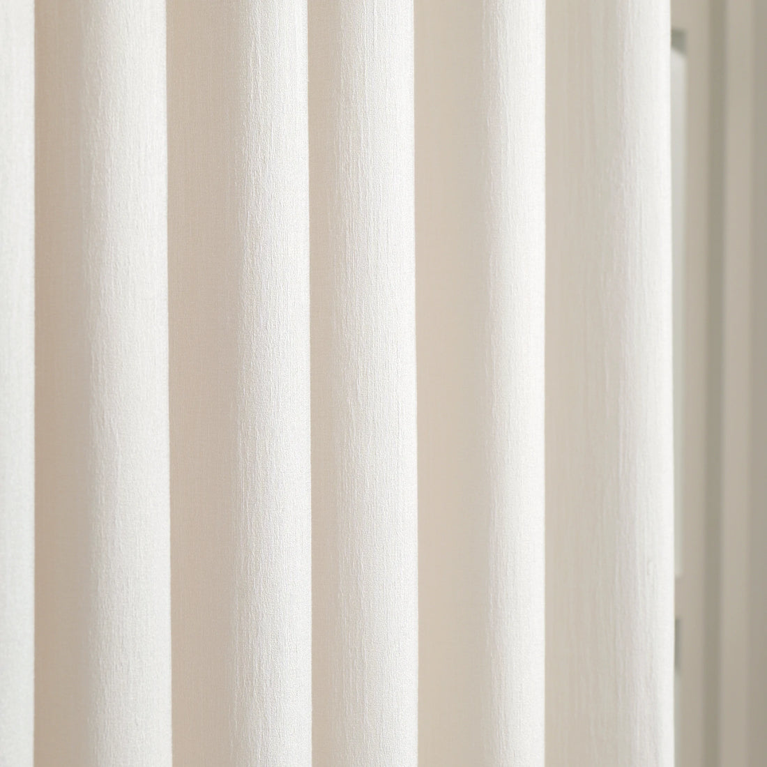Detailed vertical fabric weave of luxury Beige Sarah Semi Sheer Curtains hanging in a bedroom