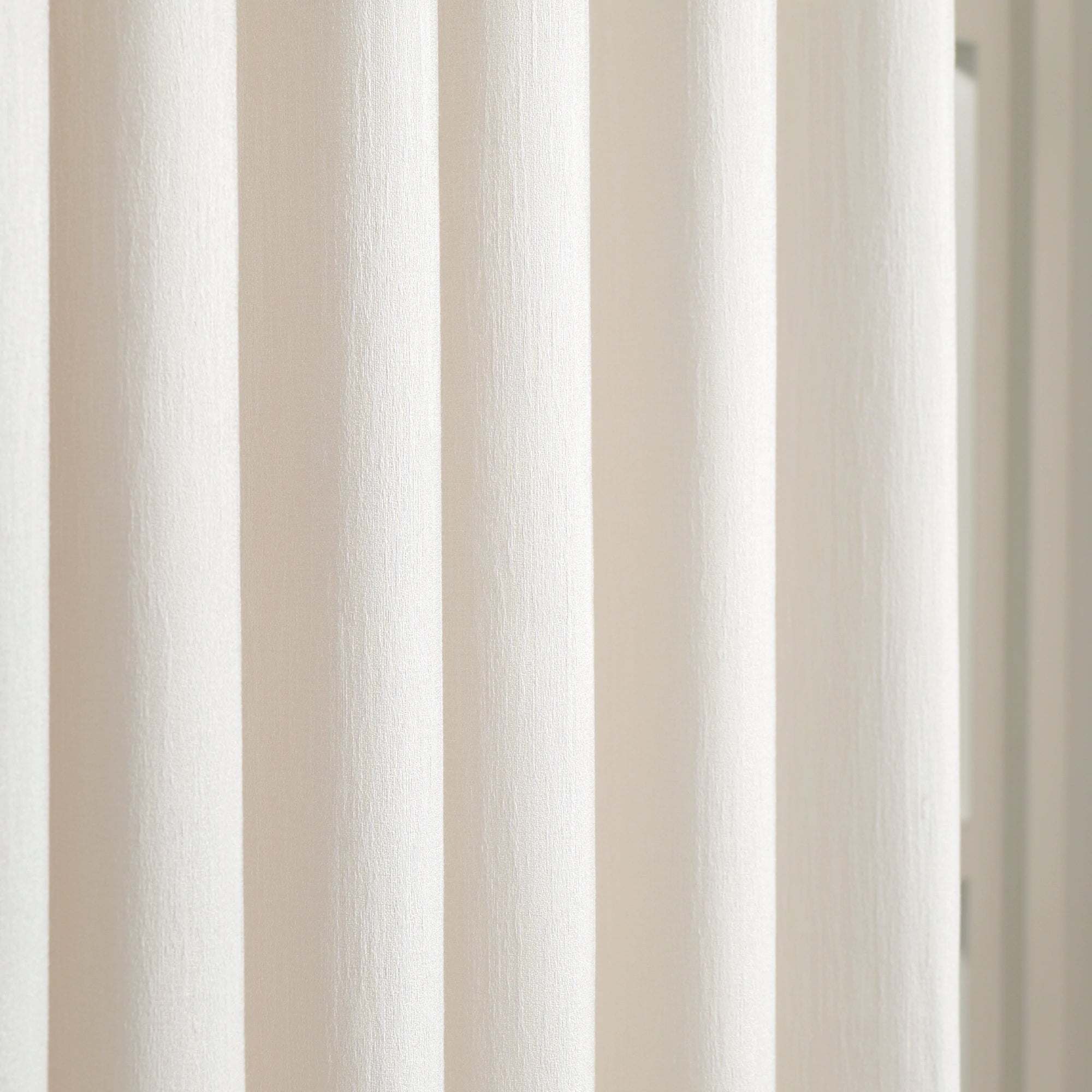 Detailed vertical fabric weave of luxury Beige Sarah Semi Sheer Curtains hanging in a bedroom