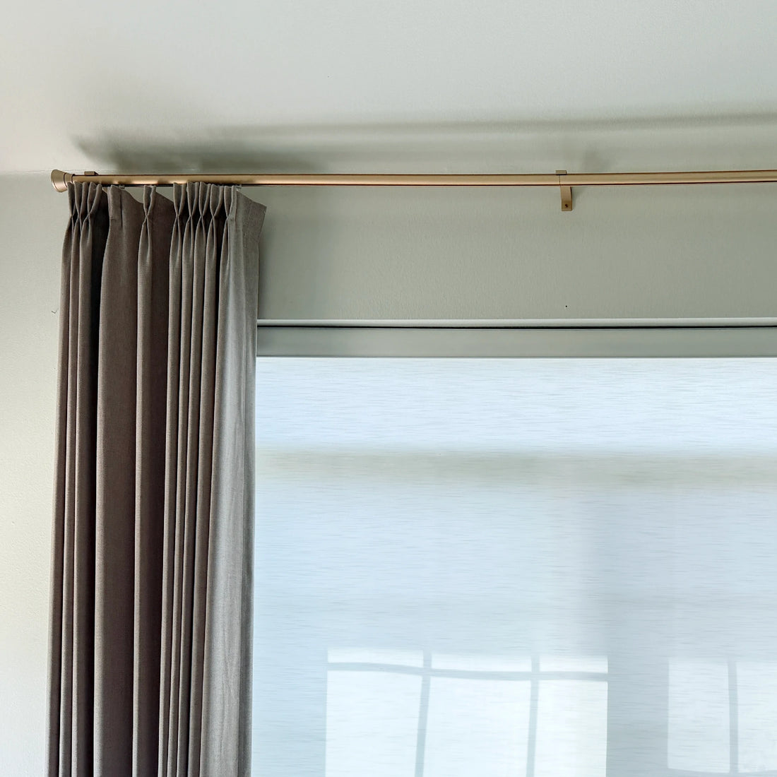 Elegant Gold Tagore Custom Traverse Rods installed close to the ceiling with pinch pleat drapery