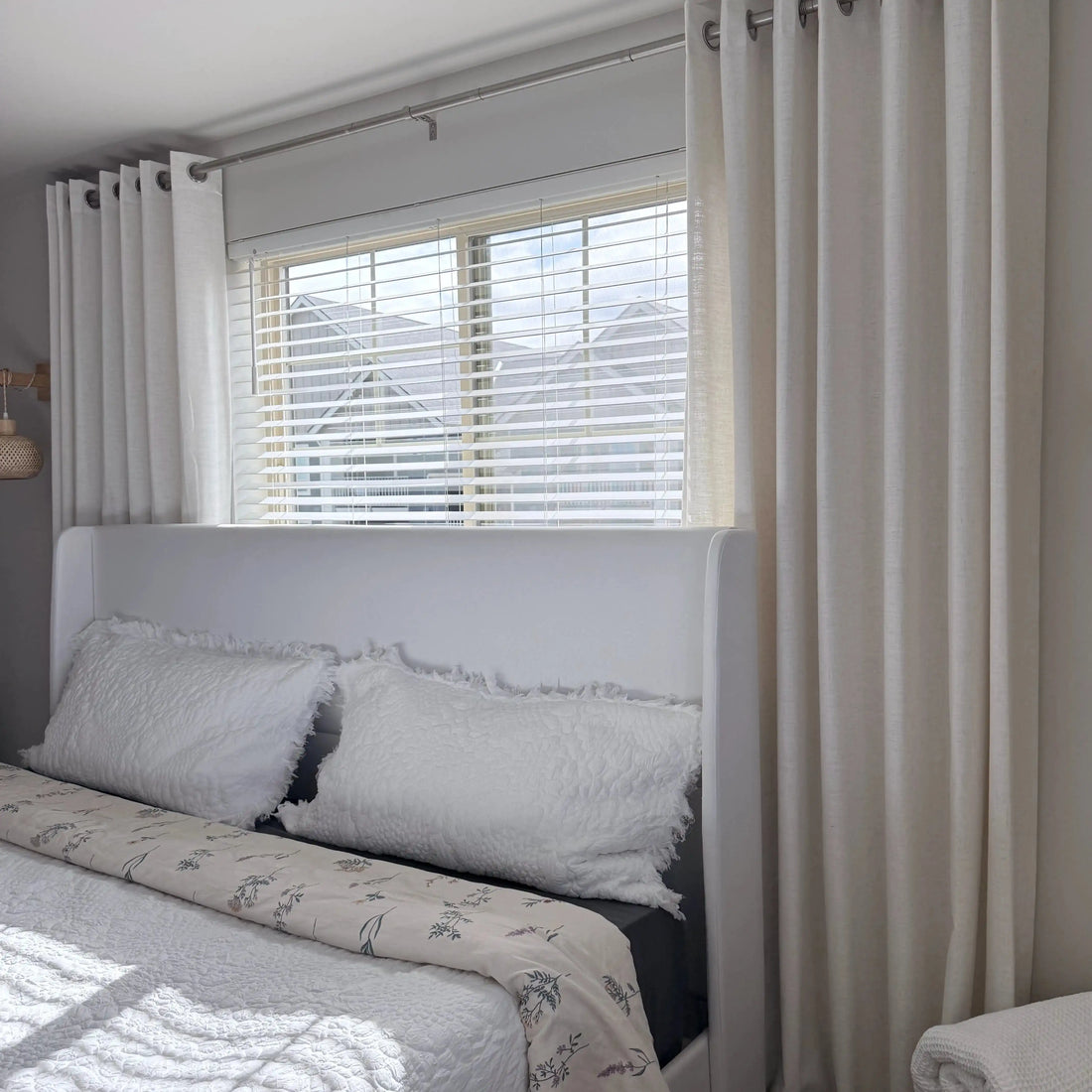 Plaid White Jasper Dotted Linen Blend Curtains with silver grommets hanging by a white bed, natural light