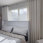 Plaid White Jasper Dotted Linen Blend Curtains with silver grommets hanging by a white bed, natural light