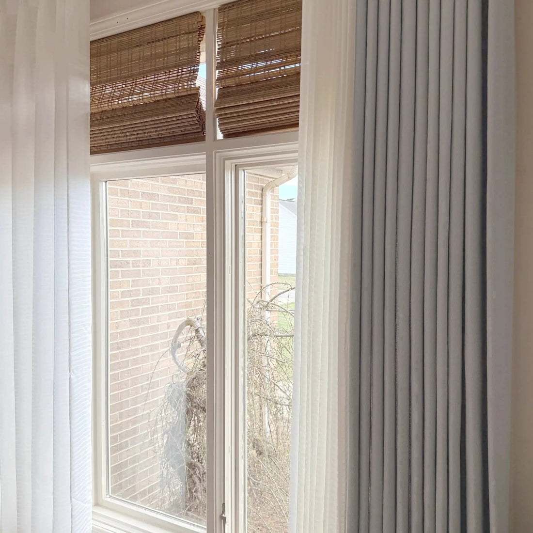 Light Gray John Linen Texture Cotton Curtains layered with white sheer panels and bamboo shades