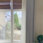 Neat vertical drapery folds of Light Gray John Linen Texture Cotton Curtains hanging in a bright space
