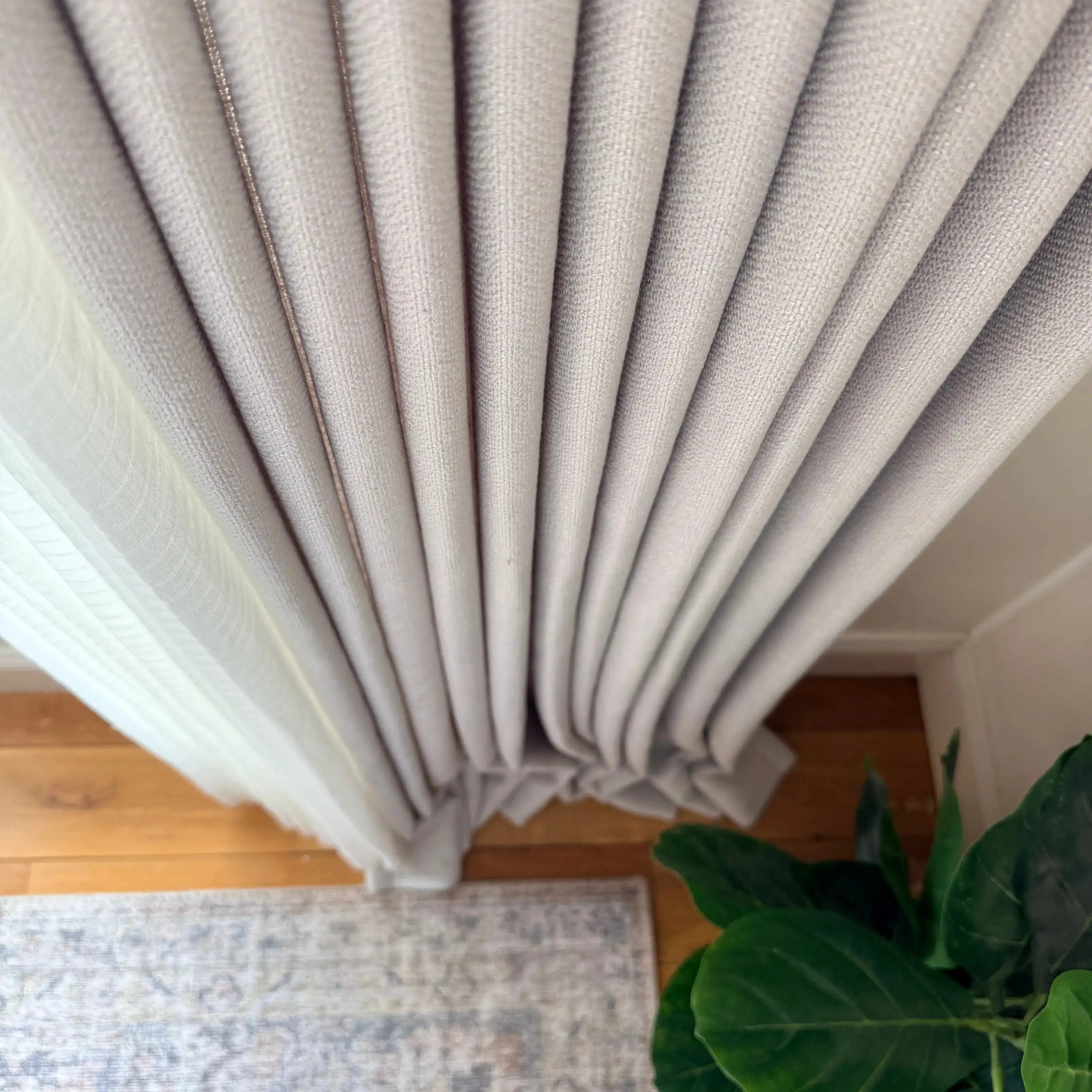 Top view of puddled fabric drapery on a wooden floor with Light Gray John Linen Texture Cotton Curtains