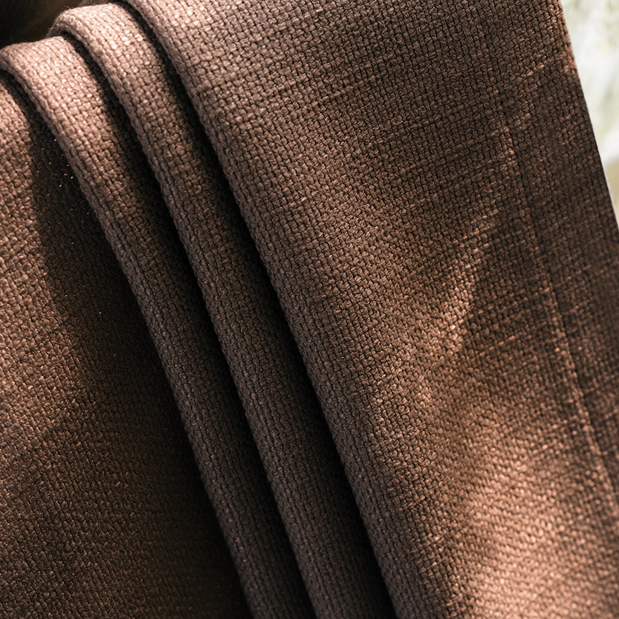 Close up material texture of Reddish Brown John Linen Texture Cotton Curtains catching soft ambient light