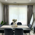Elegant living room window with beige velvet curtains and sheer white drapes, gold curtain rod, natural light, modern decor