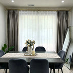 Interior view of window with beige velvet curtains and sheer white curtains, natural light, modern living space