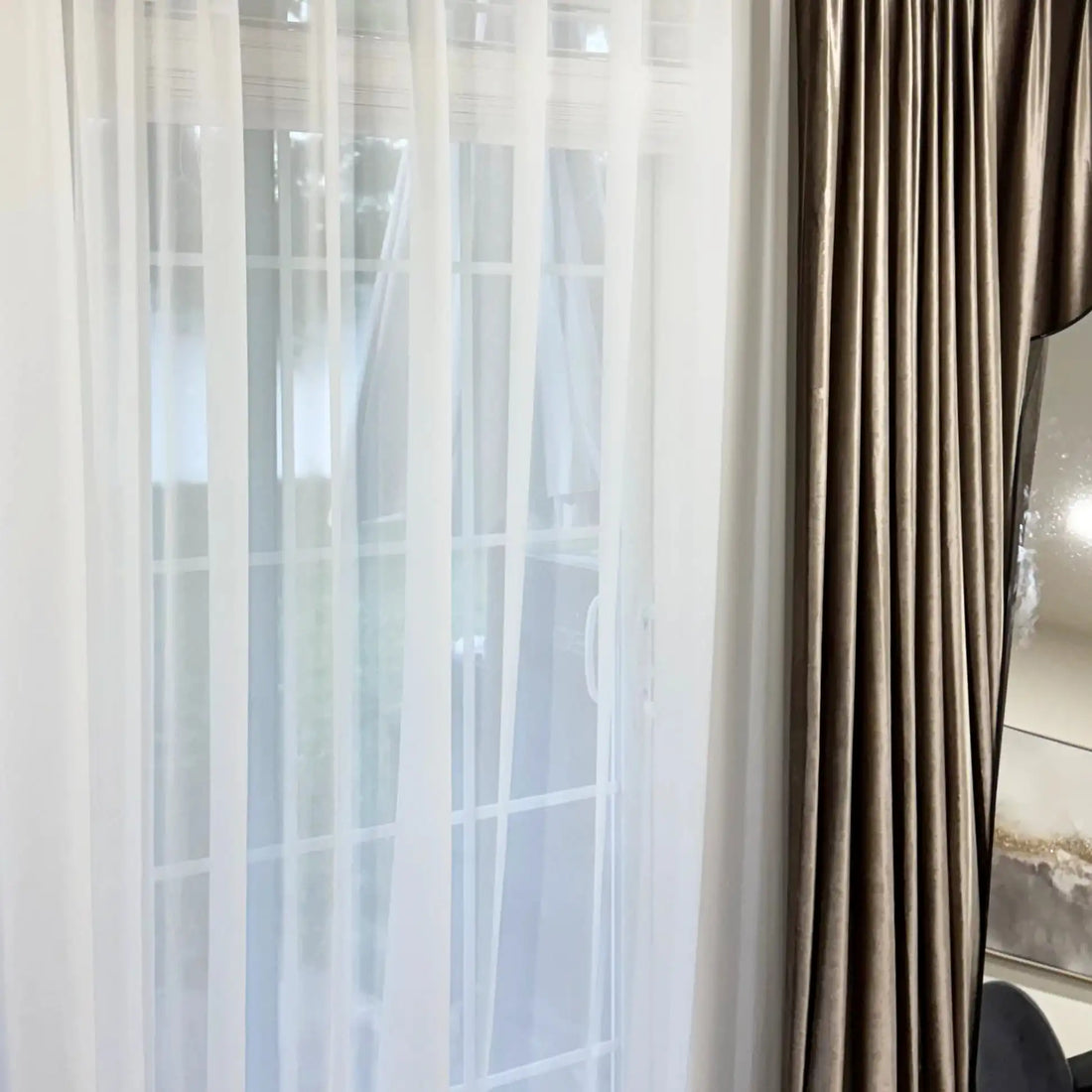 Close up of the delicate sheer fabric transparency of White Lisa Semi Sheer Curtains next to satin drapes