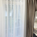 Close up of the delicate sheer fabric transparency of White Lisa Semi Sheer Curtains next to satin drapes