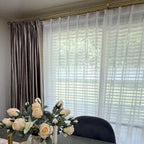 Pinch pleat White Lisa Semi Sheer Curtains layered with heavy satin drapes on a gold rod